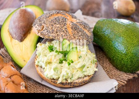 Egg and avocado spread on a poppy seed roll with fresh avocados Stock Photo