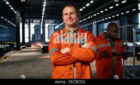 Portrait of technician oversees metal fabrication during production in workshop, highlighting heavy labor. Automation development and job responsibilities within manufacturing facility. Stock Photo
