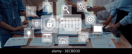 A diverse team collaborates on business strategies using digital tools, surrounded by icons symbolizing technology, security, and innovative concepts Stock Photo