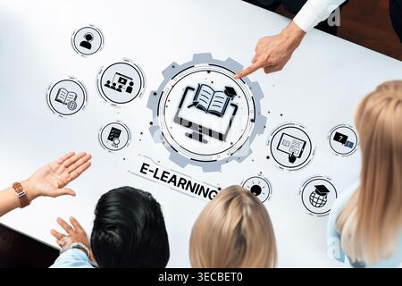 A group of diverse individuals gathers around a table, engaging in collaborative discussions on e-learning, utilizing interactive technology for educa Stock Photo