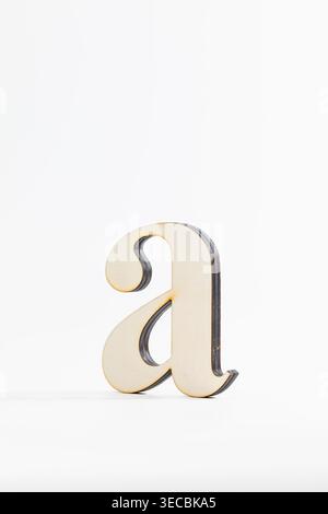Wooden letter 'a' stands alone on clean white surface. Simple design highlights its gentle, curved shape. Natural texture contrasts with smooth, minim Stock Photo