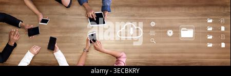 Collaborative Technology Workspace with Hands Holding Tablets and Smartphones on Wooden Table Representing Cloud Computing and Data Management Concept Stock Photo