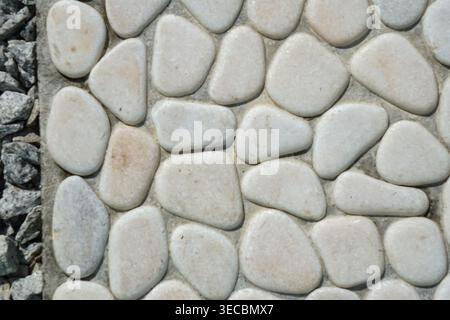 Close up of smooth embedded stones with gravel texture contrast. Stock Photo