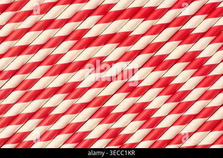 red and white striped paper straws in diagonal pattern, matte finish drink accessories in full frame texture, top view of party supply background Stock Photo