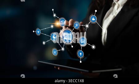 A business professional engages with a tablet displaying digital marketing concepts. The interactive icons represent innovation and strategy in a mode Stock Photo