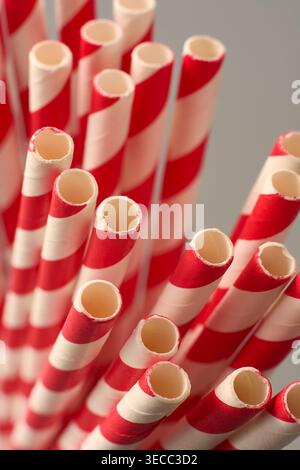 bundle of red and white striped paper straws on neutral background, matte finish drinking accessories, top view closeup macro Stock Photo