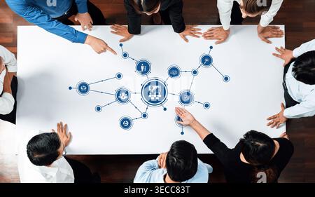Diverse business team collaborating on innovative strategies while analyzing data and digital graphics, promoting effective communication and teamwork Stock Photo