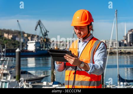 Port worker managing logistics using digital tablet Stock Photo