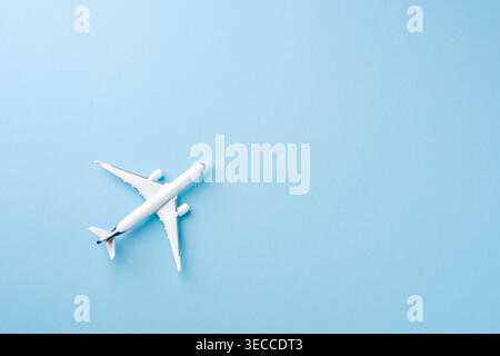 Top view of a white toy airplane on a pastel blue background Stock Photo