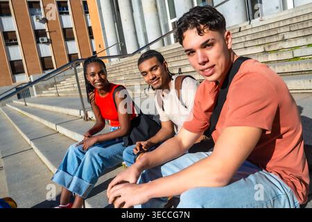 Diverse students sitting on campus stairs studying together Stock Photo