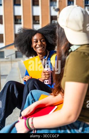 Diverse university students talking and laughing on campus stairs Stock Photo