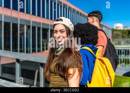 Diverse students walking on university campus smiling Stock Photo