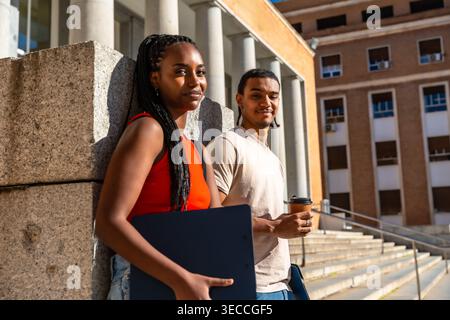 University students standing on campus building stairs Stock Photo