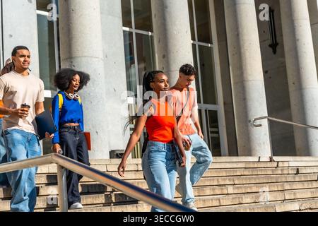 Diverse university students walking down campus stairs Stock Photo