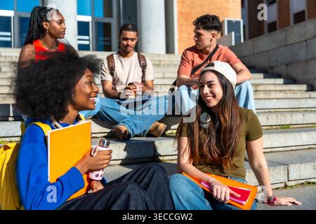 Diverse students relaxing together on university campus stairs Stock Photo