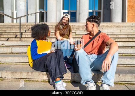 Diverse students conversing on university campus stairs Stock Photo