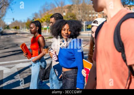 Diverse university students walking together on campus Stock Photo