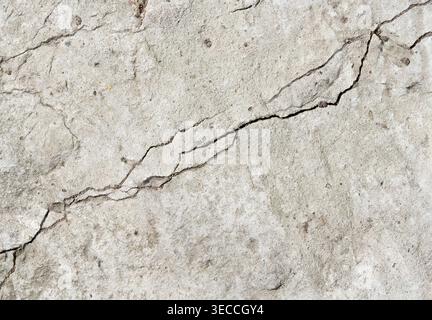 Front view macro shot of a deep split crack in a weathered concrete wall Stock Photo