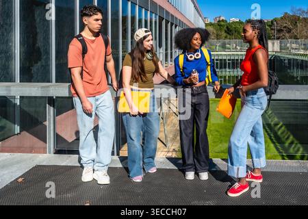 Diverse students conversing on university campus Stock Photo