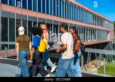 Diverse students walking on university campus, learning and collaborating Stock Photo