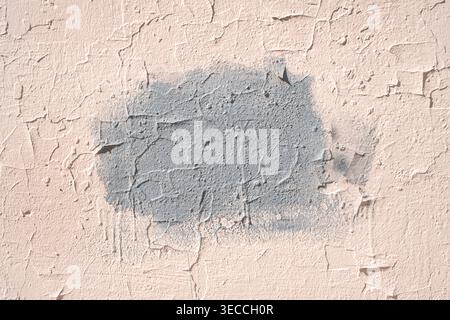 Front view of an old stucco wall with a gray painted rectangular patch in the center for copy space Stock Photo