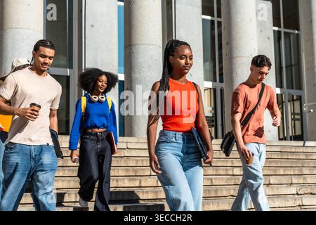 Diverse students walking down university campus stairs Stock Photo
