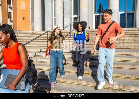 Multi ethnic students walking down university campus stairs Stock Photo