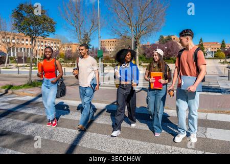 Group of diverse university students crossing campus street Stock Photo