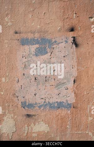 Front view of an old stucco wall with a rectangular patch of painted shadow mask Stock Photo