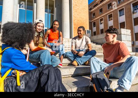 Diverse students engaging in discussion on university campus stairs Stock Photo