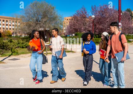 Diverse students walking on university campus discussing education Stock Photo