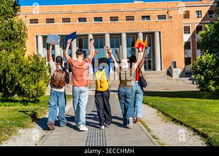 Diverse students celebrating success on university campus Stock Photo