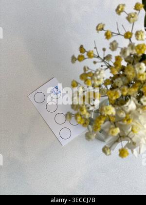 Loyalty card on table with flowers, soft daylight, minimal cafe aesthetic scene Stock Photo