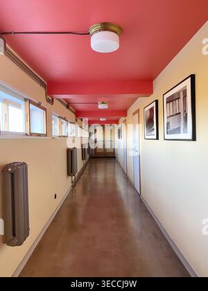 Modern corridor interior with red ceiling, minimal architecture, long hallway with doors, windows and industrial details Stock Photo