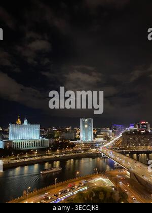 Moscow, Russia - October 24 2021:  Night cityscape with illuminated buildings and river, urban skyline with traffic lights Stock Photo
