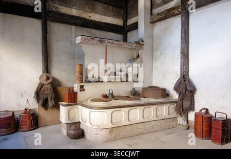 Traditional old kitchen showcasing a large hearth, pots, and period items in Deshou Palace in Hangzhou, China Stock Photo
