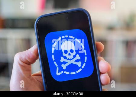 Symbolfoto zur Cyber-Spionage auf Signal: Ein Smartphone zeigt eine manipulierte Version des Messenger-Logos mit Totenkopf-Symbol. Illustration der großangelegten Phishing-Angriffe auf deutsche Regierungsmitglieder und Parlamentarier im Frühjahr 2026. *** Symbolic image illustrating cyber espionage on Signal: a smartphone displaying a manipulated version of the messaging apps logo featuring a skull and crossbones. Illustration of the large-scale phishing attacks targeting German government officials and MPs in spring 2026. Nordrhein-Westfalen Deutschland, Germany 20260430-DSCF3266 Stock Photo