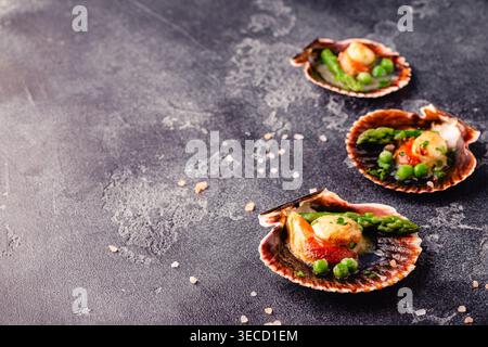 Cooked scallops with vegetables on a dark background Stock Photo