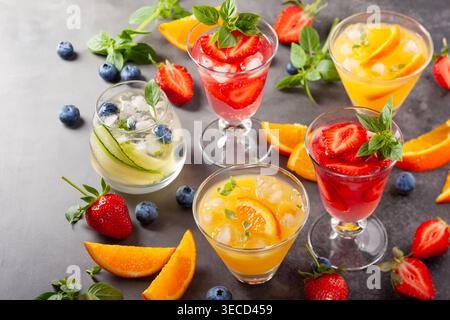 Assortment summer non-alcoholic cocktails with fresh berries, herbs and fruits on dark background. Stock Photo