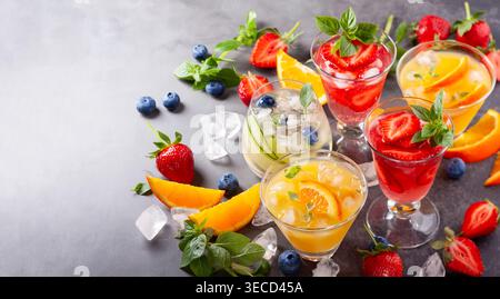 Assortment summer non-alcoholic cocktails with fresh berries, herbs and fruits on dark background. Stock Photo