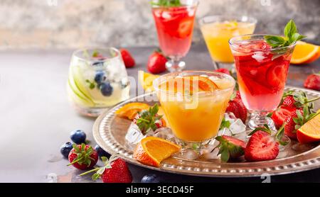 Assortment summer non-alcoholic cocktails with fresh berries, herbs and fruits on dark background. Stock Photo