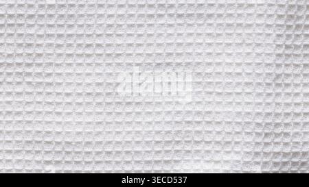 White waffle weave fabric texture with square grid pattern as a clean background close-up Stock Photo