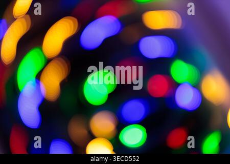 Colorful defocused bokeh lights of Christmas garland with blue green yellow red glow for festive holiday background Stock Photo