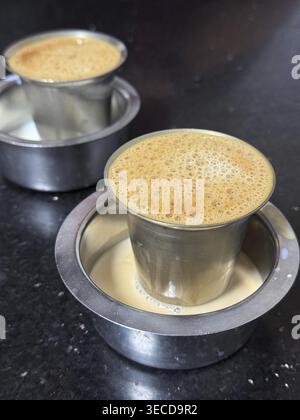 Indian filter coffee with creamy foam served in traditional stainless steel tumblers, Vellore, Tamil Nadu, India Stock Photo