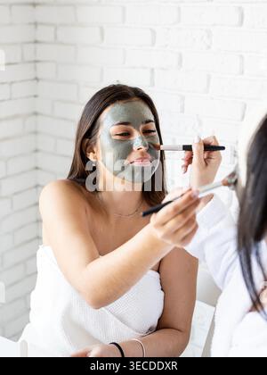 Spa and wellness concept. Self care. two beautiful women applying facial mask having fun Stock Photo