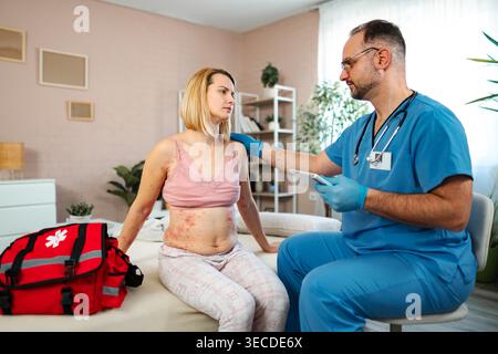 Doctor examining skin rash on a woman at home for allergy or infection Stock Photo