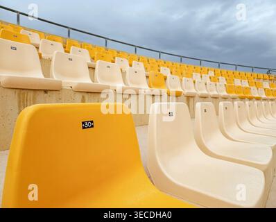 Yellow Stadium Seat in Foreground with Empty Rows Behind Stock Photo