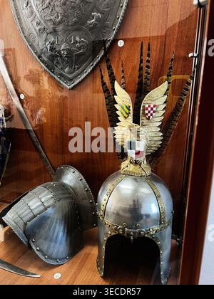Zolochiv, Ukraine - April 28, 2026: Decorative plumed Polish hussars helmet with eagle crest and long feathers showcased alongside historic armor and Stock Photo