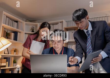 Business team discussing project data in office, analyzing reports and collaborating on strategy with laptops and documents, representing teamwork, co Stock Photo