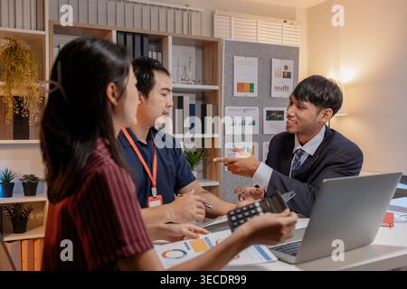 Business team discussing project data in office, analyzing reports and collaborating on strategy with laptops and documents, representing teamwork, co Stock Photo